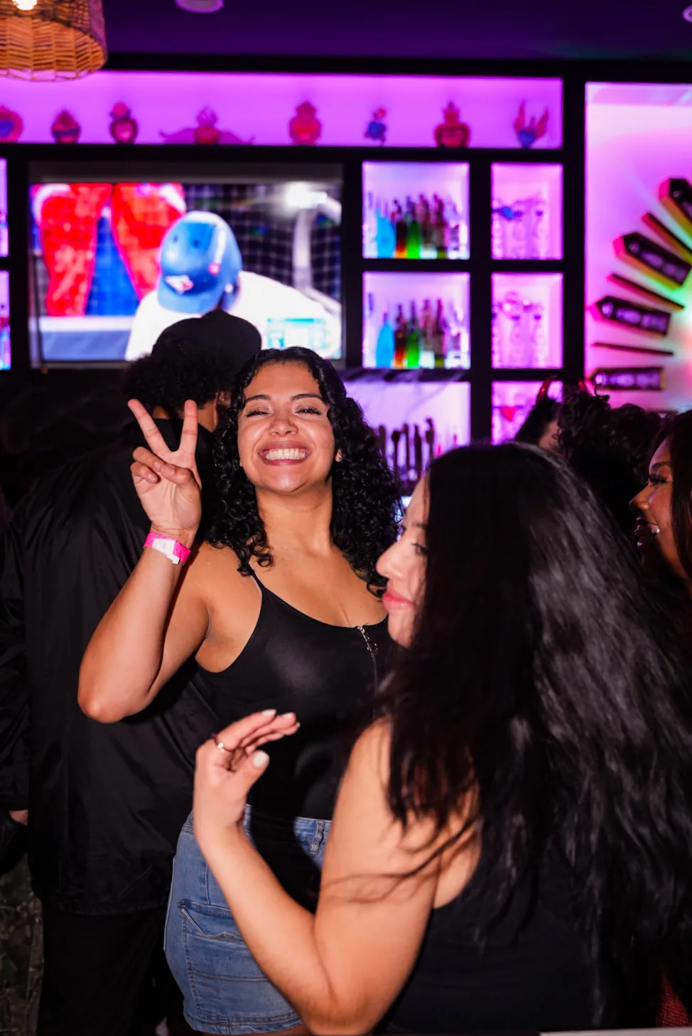 Two friends dancing in the bar area, one smiling and throwing a peace sign