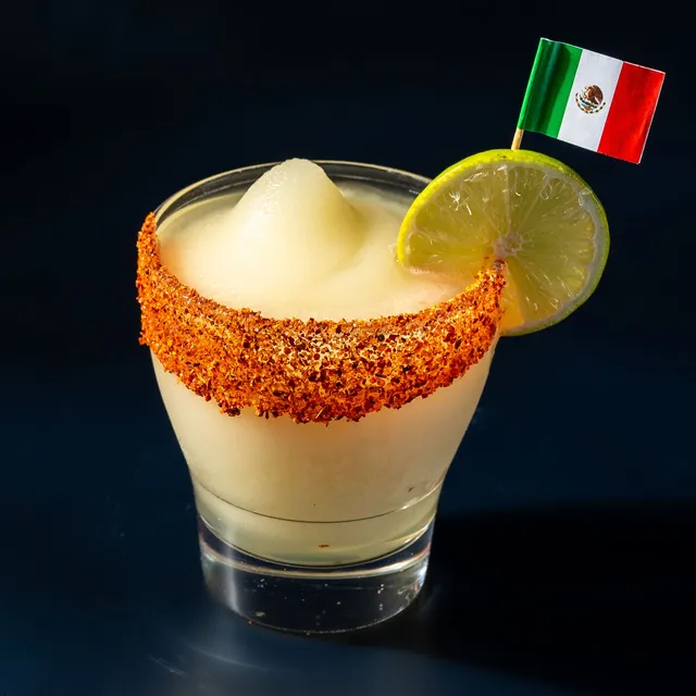 Frozen lime margarita with a chile rim and a lime wheel