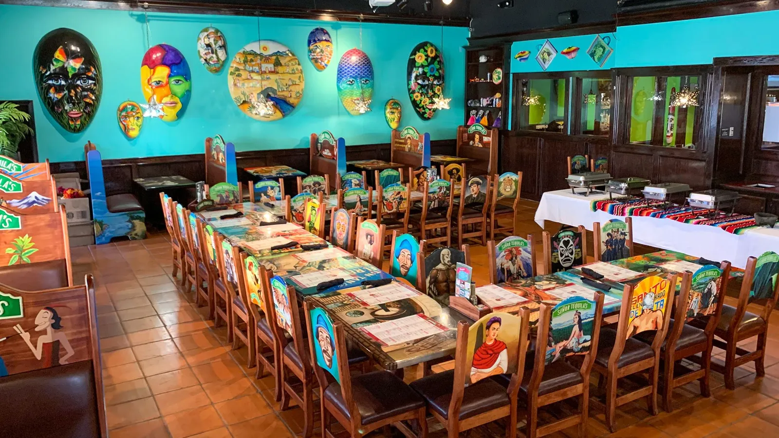 The International Room set with long tables and painted chairs, flags along the ceiling
